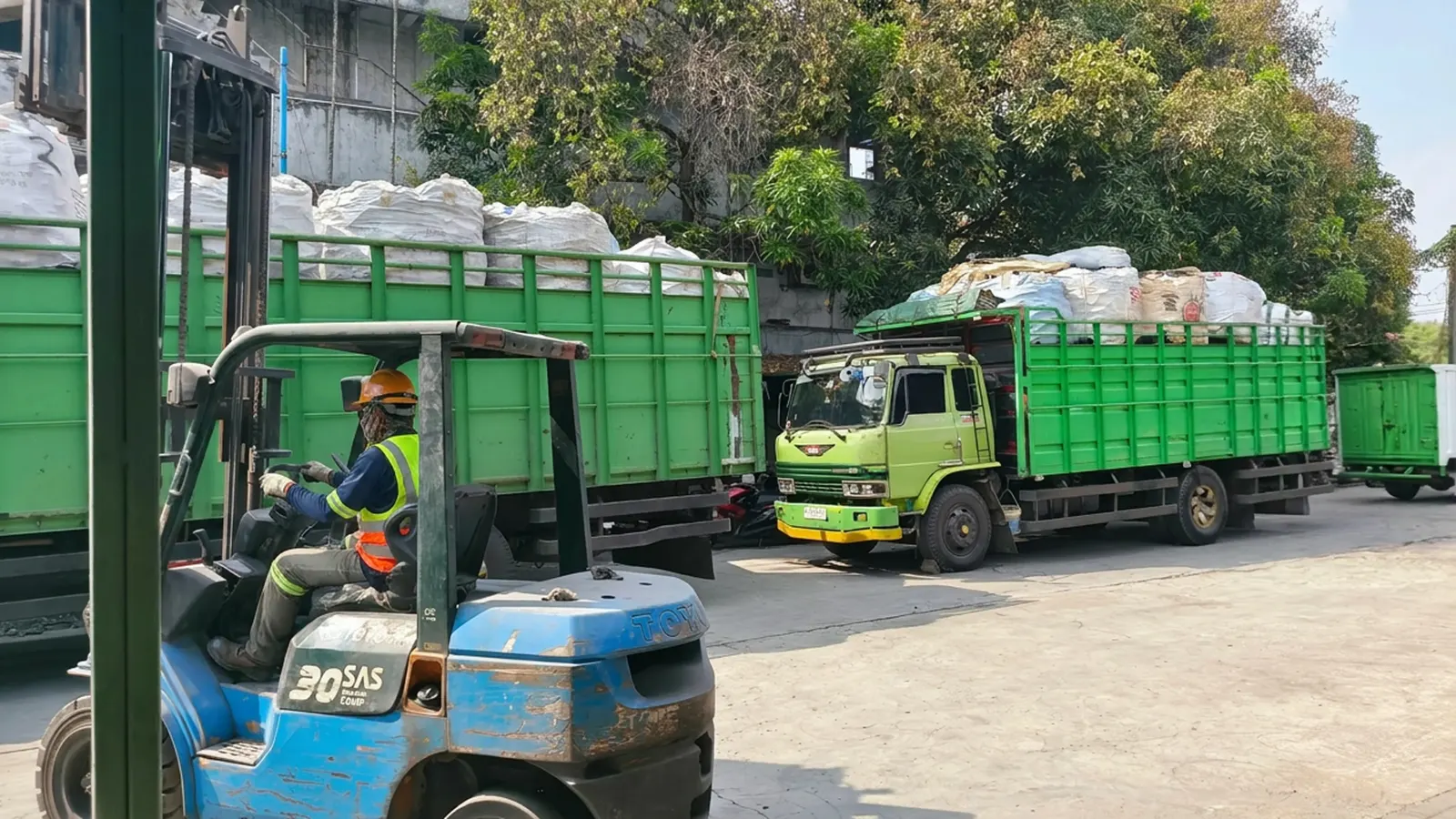 Forklift mengangkat muatan baja di gudang PT SKBU